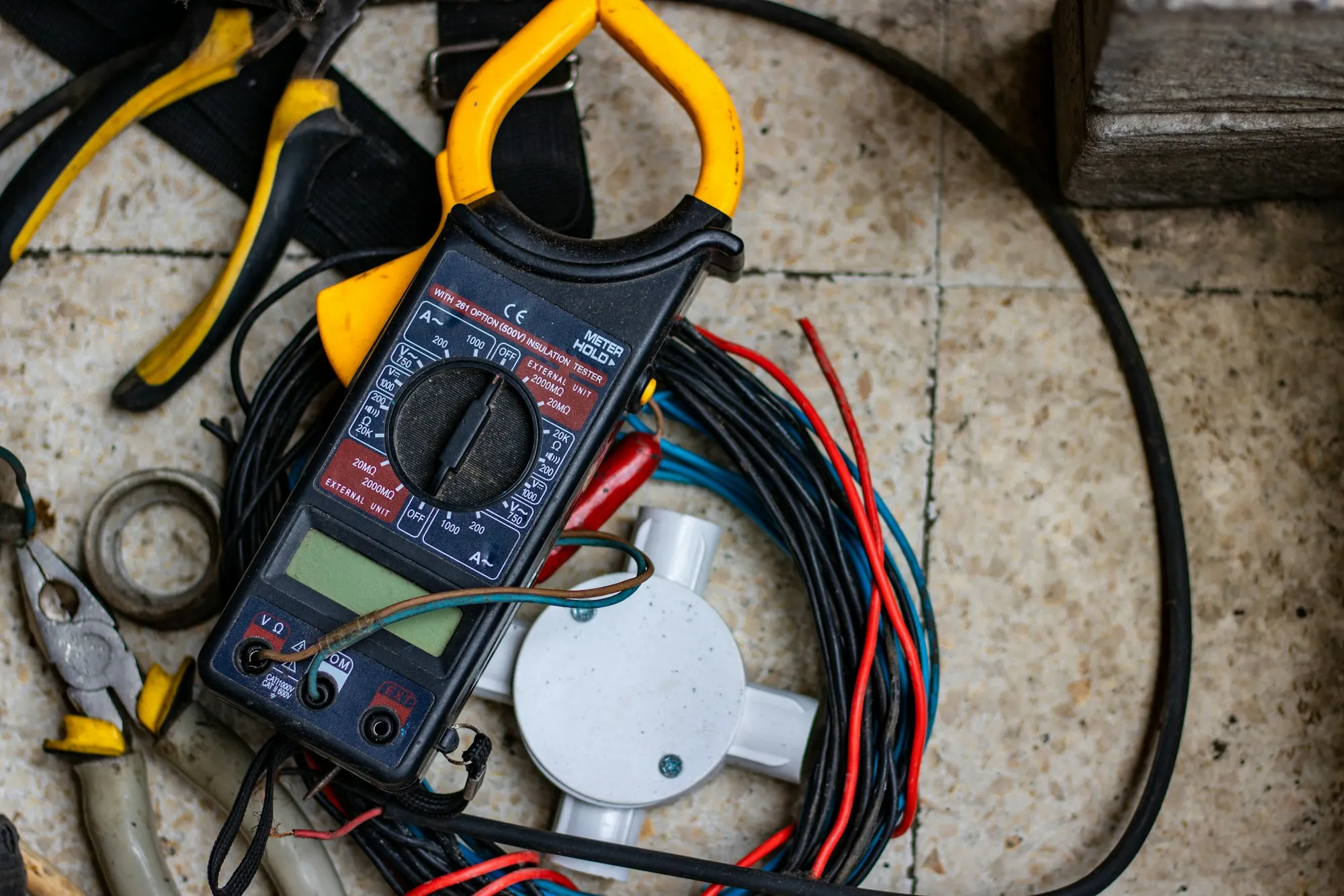 Clamp meter among wires and hand tools